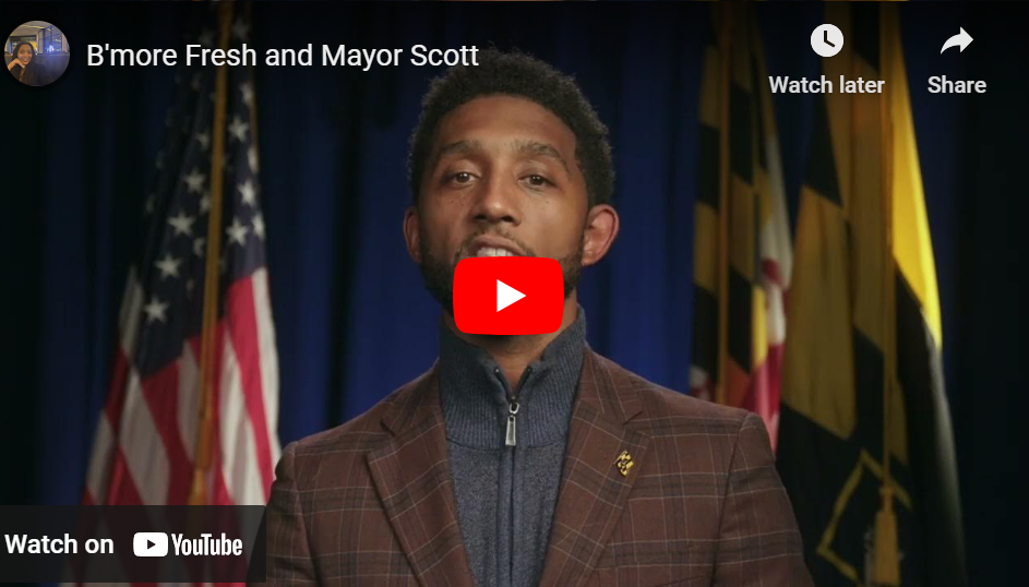 Photo of Baltimore City Mayor brandon scott with a banner that reads B'more Fresh $30 produce vouchers 